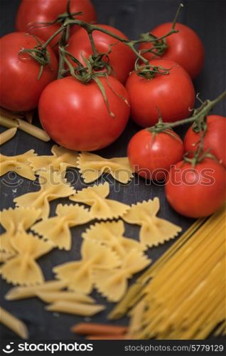 food background on rustic wood with pasta and tomatoes. food background