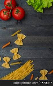 food background on rustic wood with pasta and tomatoes. food background