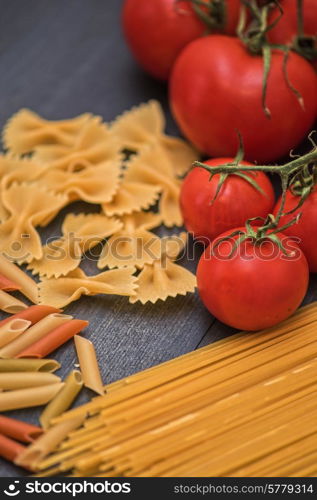 food background on rustic wood with pasta and tomatoes. food background