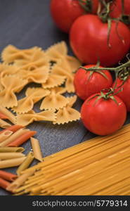 food background on rustic wood with pasta and tomatoes. food background