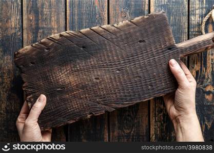 food background with blank space, woman&rsquo;s hands holding wooden cutting board above rustic wooden table top
