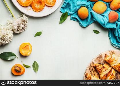 Food background with croissants and apricots to breakfast on light mint background , top view. Frame