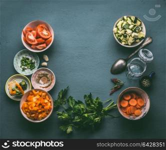 Food background with fresh diced vegetables , cooking spoon and glass jar, top view, frame. Healthy vegetarian food and cooking concept. Homemade lunch in jar making ingredients.