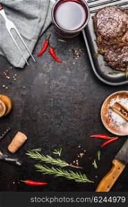 Food background with grilled Steak Ribeye on grill iron pan on rustic metal background with red wine, herbs and spices, top view