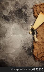 Food background with parmesan cheese over dark stone background. Lots of copy space