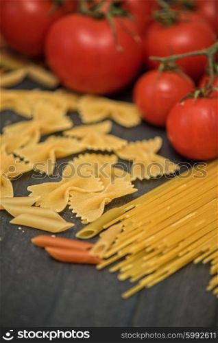 food background with pasta . food background on rustic wood with pasta and tomatoes