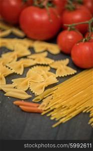 food background with pasta . food background on rustic wood with pasta and tomatoes