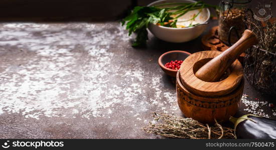 Food background with pestle and mortar, herbs and spices on dark rustic background. Copy space