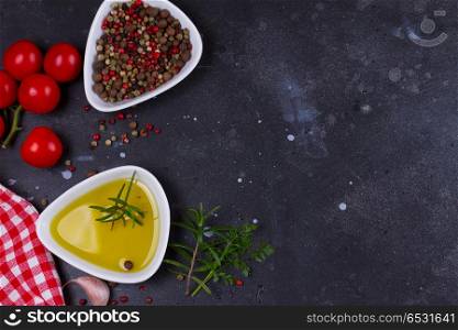 Food background with spices. Food background - olive oil and pper spices on black stone background, flat lay scene