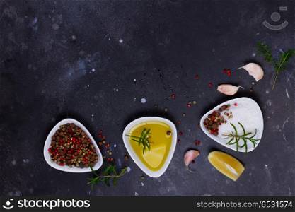 Food background with spices. Food background - spices and salt with olive oil and garlic on black background