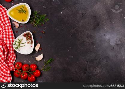 Food background with spices. Food background - spices, olive oil and tomatoes on black stone background with copy space