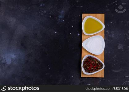 Food background with spices. Food background - spices with olive oil on black background, top view