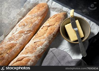 food, baking and cooking concept - close up of bread, butter in bowl and table knife on towel. close up of bread, butter and knife on towel
