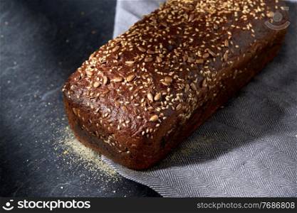 food, baking and cooking concept - close up of homemade craft bread with sesame and sunflower seeds on table. homemade craft bread with seeds on table