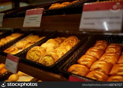 food, baking and sale concept - close up of buns at bakery or grocery store