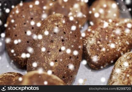 food, baking and sale concept - close up of rye bread at bakery or grocery store over snow. close up of rye bread at bakery or grocery store