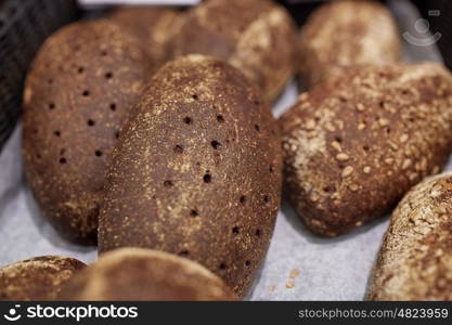 food, baking and sale concept - close up of rye bread at bakery or grocery store