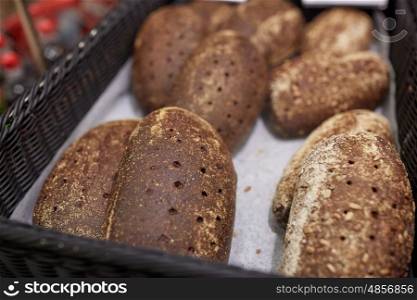 food, baking and sale concept - close up of rye bread at bakery or grocery store