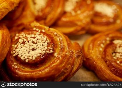 food, baking, sweets and sale concept - close up of buns at bakery or grocery store