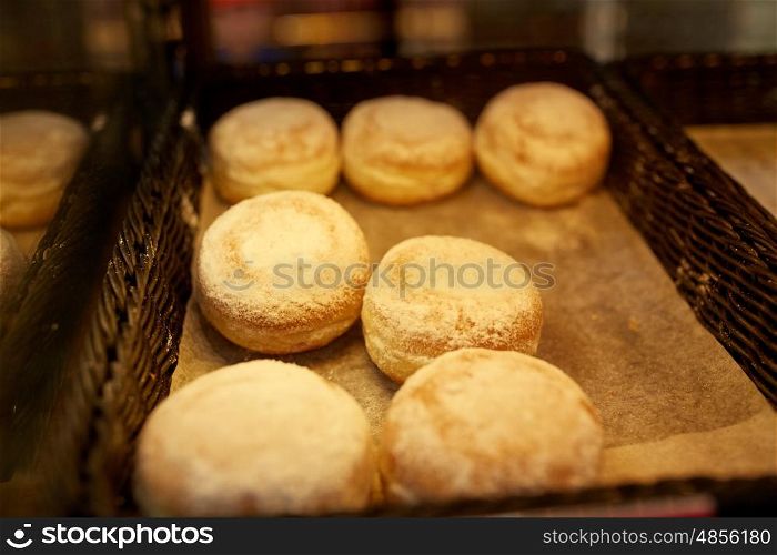 food, baking, sweets and sale concept - close up of buns at bakery or grocery store