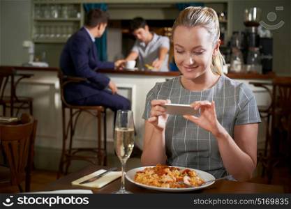 Food Blogger Taking Picture Of Restaurant Meal On Mobile Phone
