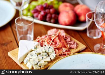 food, catering and eating concept - blue cheese and jamon ham on wooden table. blue cheese and jamon ham on wooden table