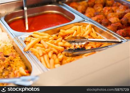food, catering, self-service and eating concept - close up of french fries and other dishes on metallic tray