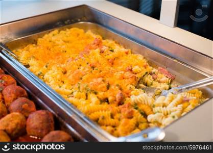 food, catering, self-service and eating concept - close up of pasta and meatballs on metallic tray
