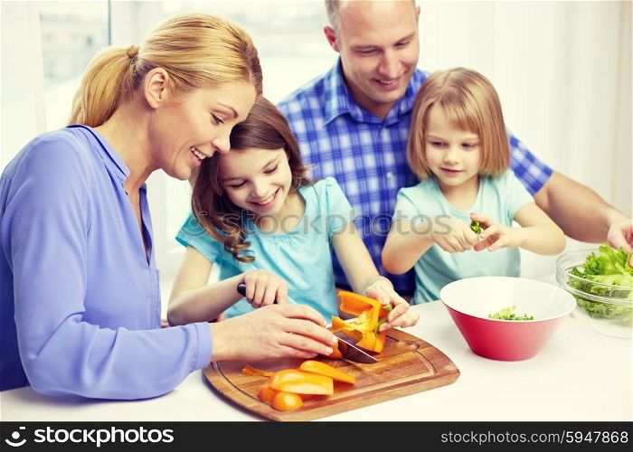 food, children, culinary and people concept - happy family with two kids cooking vegetables at home