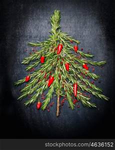 Food Christmas tree made of fresh rosemary and red chili on dark background, top view