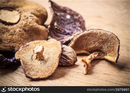 Food. Closeup dry mushrooms on wooden rustic table background.
