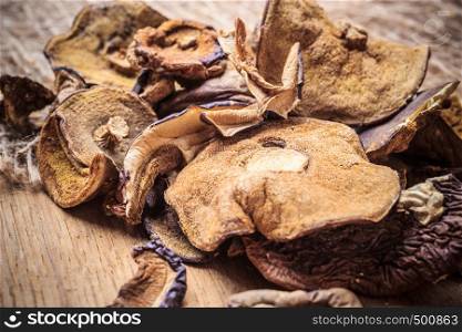 Food. Closeup dry mushrooms on wooden rustic table background.