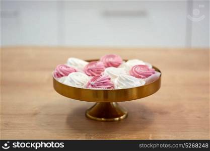food, confection and sweets concept - zephyr, marshmallow or whipped cream on cake stand. zephyr or marshmallow on cake stand