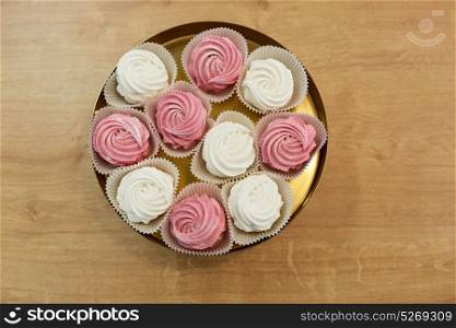food, confection and sweets concept - zephyr, marshmallow or whipped cream on cake stand. zephyr or marshmallow on cake stand