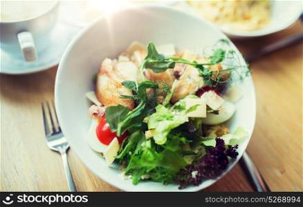 food, cooking and eating concept - close up of caesar salad on plate at restaurant or home. close up of caesar salad on plate at restaurant