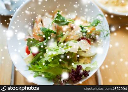 food, cooking and eating concept - close up of caesar salad on plate at restaurant