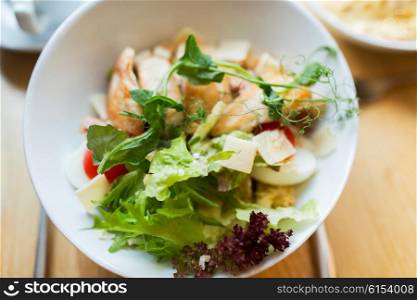 food, cooking and eating concept - close up of caesar salad on plate at restaurant