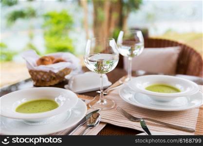 food, cooking and eating concept - close up of creamy soup and water glasses on table at restaurant or home