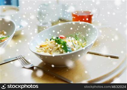 food, cooking and eating concept - close up of pasta in bowl on table at restaurant or home