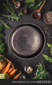 Food cooking and healthy eating background with empty dark rustic plate and fresh seasoning, spoon and vegetables ingredients, top view. Copy space for your text and design