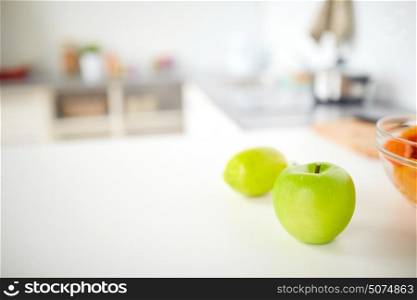 food, cooking and healthy eating concept - apple on home kitchen table. apple on home kitchen table