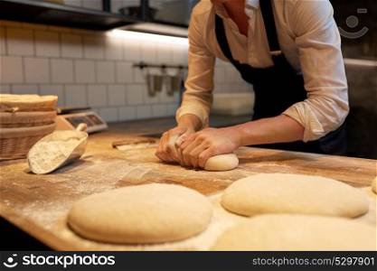 food cooking, baking and people concept - baker making bread dough at bakery kitchen. baker making bread dough at bakery kitchen
