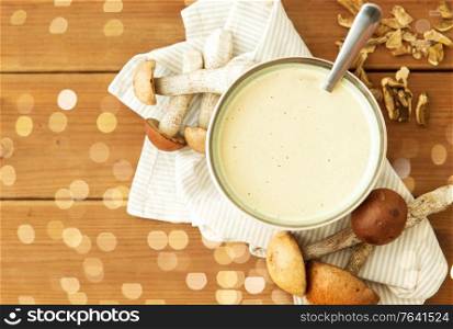 food cooking, eating and culinary concept - mushroom cream soup in bowl on wooden cutting board. mushroom cream soup in bowl on cutting board