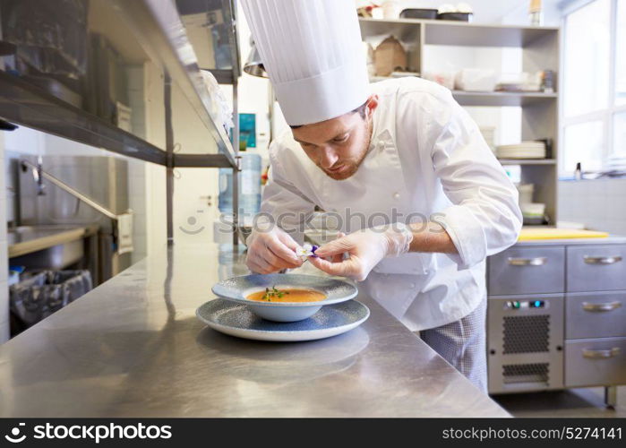 food cooking, profession and people concept - happy male chef cook serving and decorating plate of soup with flower at restaurant kitchen. happy male chef cooking food at restaurant kitchen