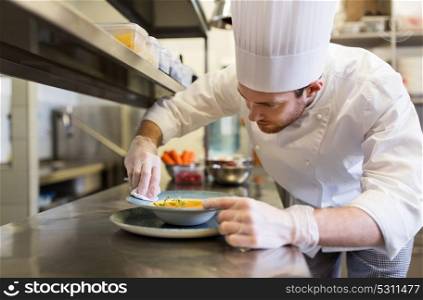 food cooking, profession and people concept - happy male chef cook serving plate of soup at restaurant kitchen. happy male chef cooking food at restaurant kitchen