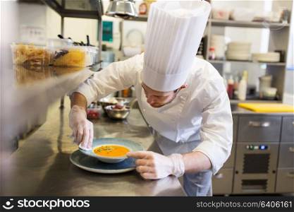 food cooking, profession and people concept - happy male chef cook serving plate of soup at restaurant kitchen. happy male chef cooking food at restaurant kitchen