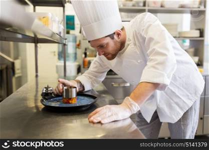 food cooking, profession and people concept - happy male chef cook with mold serving stewed vegetables on plate at restaurant kitchen. happy male chef cooking food at restaurant kitchen