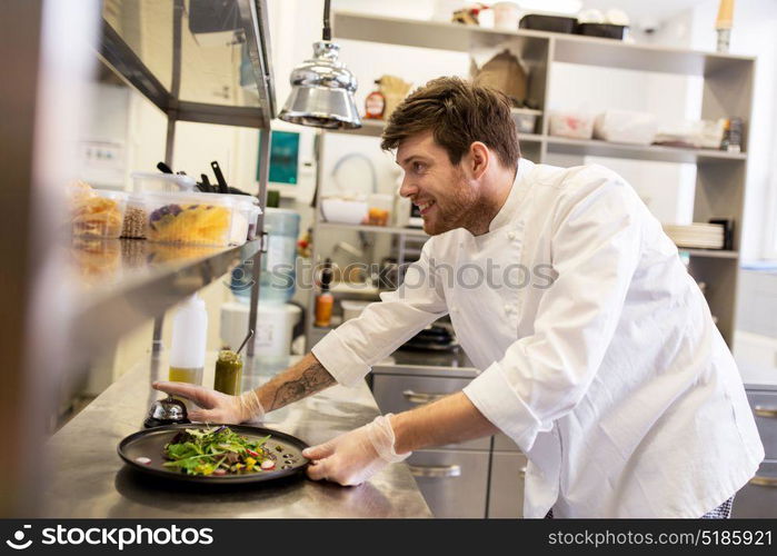 food cooking, profession and people concept - happy male chef cook with plate of soup and salad at restaurant kitchen table. happy male chef cooking food at restaurant kitchen