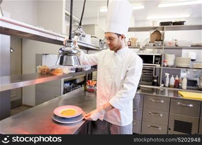 food cooking, profession and people concept - happy male chef cook with cloche and soup at restaurant kitchen. happy male chef cooking food at restaurant kitchen