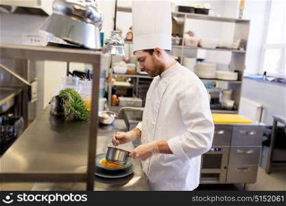 food cooking, profession and people concept - male chef cook with pot serving plate of soup at restaurant kitchen. chef with pot cooking and serving food at kitchen